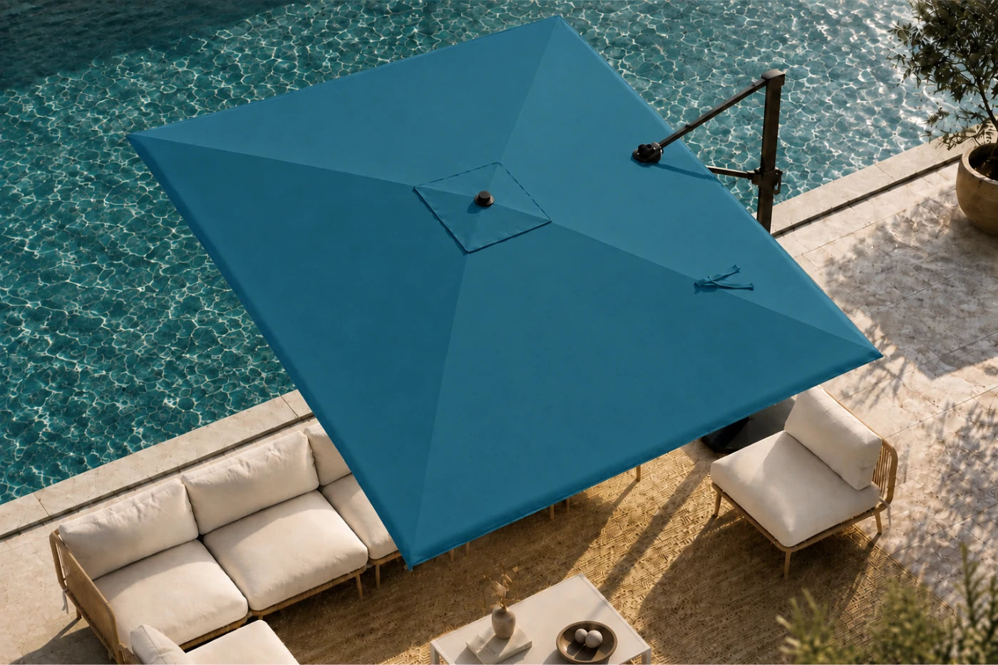 A large cantilever patio umbrella in a lake blue color, shown in a lifestyle setting next to a swimming pool with outdoor lounge chairs and a sofa.